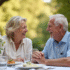 Couple agee main dans la main souriant en plein air